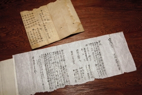 神子畑が千円を受け取ることになった経緯が書かれた書面と利息の帳簿＝朝来市佐囊