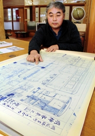 養父市教育委員会に寄贈した一円電車の設計図を示す岡本憲之さん＝同市大屋町明延