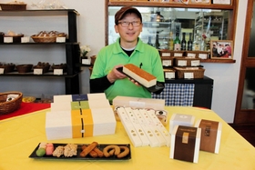 姫路城と銀の馬車道の焼き菓子を４種類ずつ開発した洋菓子店「菓子工房　菓音」の井上さん＝姫路市北平野２