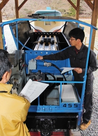 バッテリー式機関車を点検する地元の住民ら＝養父市大屋町明延