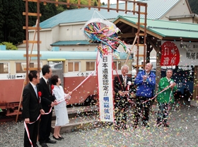 スズをイメージしたくす玉を割って日本遺産認定を祝う関係者＝養父市大屋町明延