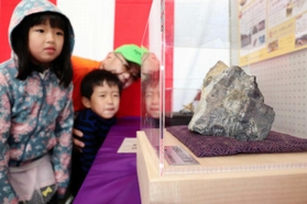 中瀬鉱山で採れた金の鉱石の展示。子どもたちも興味津々の様子だった＝養父市中瀬