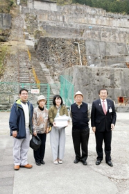 日本遺産の認定後、観光客１万人目となった切山一朗さん（左端）と家族ら＝朝来市佐嚢、神子畑選鉱場跡