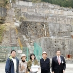 日本遺産の認定後、観光客１万人目となった切山一朗さん（左端）と家族ら＝朝来市佐嚢、神子畑選鉱場跡