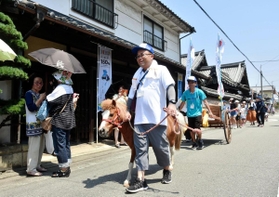 馬車をイメージしたポニーと大八車を先頭に街道を歩く住民ら＝姫路市安田２