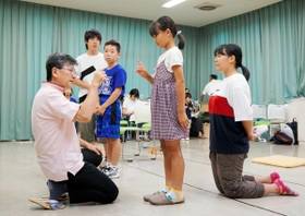 本番に向けて稽古に励む劇団員と上田浩人さん（左）＝福崎町西田原