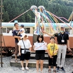 「一円電車体験乗車会」の３万人目の利用者となった明石市の村井凜さん（中央）や家族ら＝養父市大屋町明延