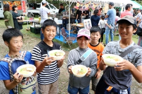 人気店のラーメンを手にして笑顔を見せる子どもたち＝生野銀山駐車場
