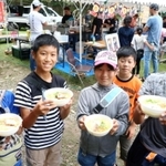 人気店のラーメンを手にして笑顔を見せる子どもたち＝生野銀山駐車場