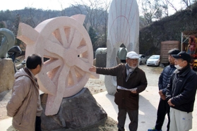 制作中のアート作品を紹介する牛尾啓三さん（右から３人目）＝加西市西長町