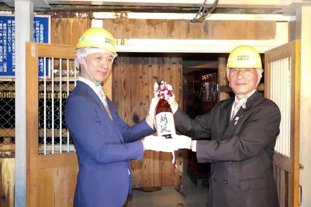 １年間熟成させた純米酒「明延」を蔵出しした山陽盃酒造の壺阪雄一専務（左）と養父市の広瀬栄市長＝明延鉱山探検坑道