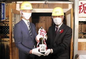 蔵出しした「仙櫻」を手にする山陽盃酒造の壺阪雄一専務（左）と養父市の広瀬栄市長＝明延鉱山探検坑道
