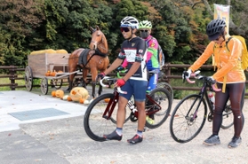 馬車のモニュメント付近で自転車を降りて休憩する参加者＝神河町吉冨