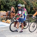馬車のモニュメント付近で自転車を降りて休憩する参加者＝神河町吉冨