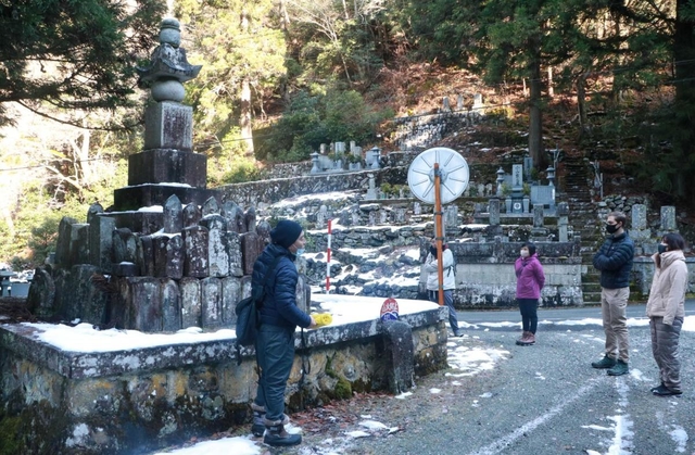 無縁塔について参加者に説明する佐藤次郎さん（左端）＝朝来市生野町白口