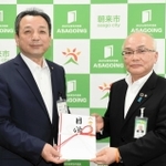 藤岡市長（左）に目録を手渡した但陽信用金庫の大西専務理事＝朝来市役所