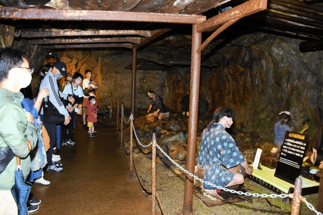 説明を聞きながら銀山ボーイズを見守る参加者たち＝史跡・生野銀山