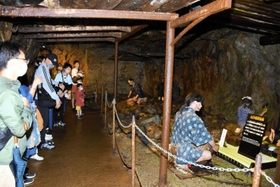説明を聞きながら銀山ボーイズを見守る参加者たち＝史跡・生野銀山