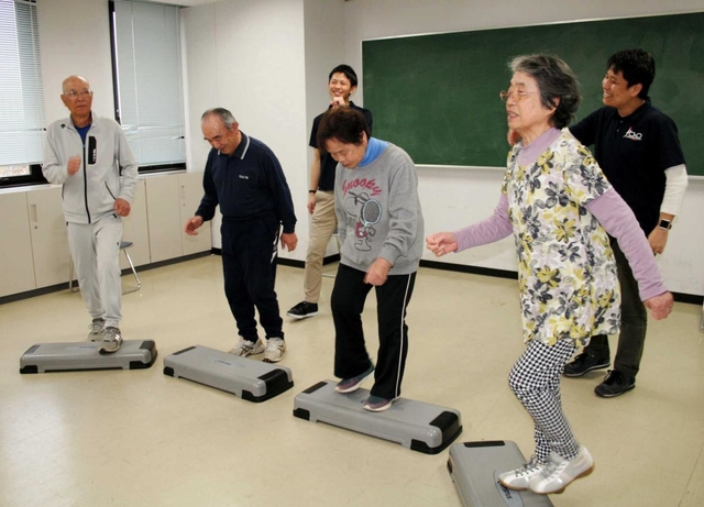 神戸大院生の指導の下、二重課題運動に楽しく取り組む高齢者＝神戸市須磨区友が丘