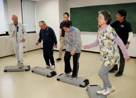 神戸大院生の指導の下、二重課題運動に楽しく取り組む高齢者＝神戸市須磨区友が丘