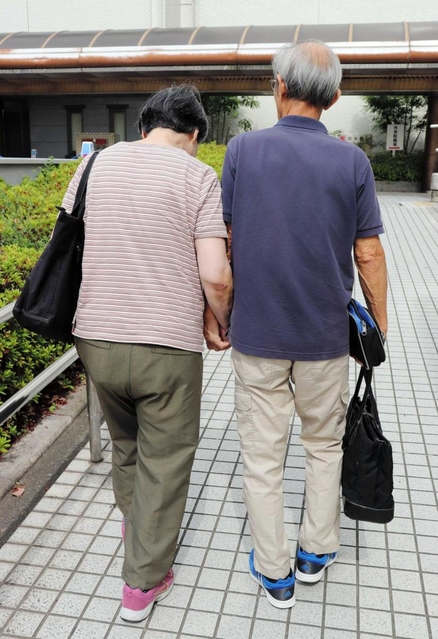 夫と手をつなぎ病院へ向かう女性＝神戸市中央区楠町７