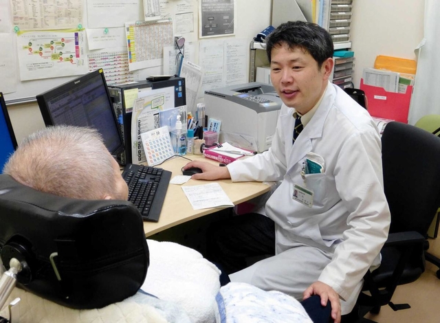 男性を診療する古和久朋教授（右）＝神戸市中央区楠町７