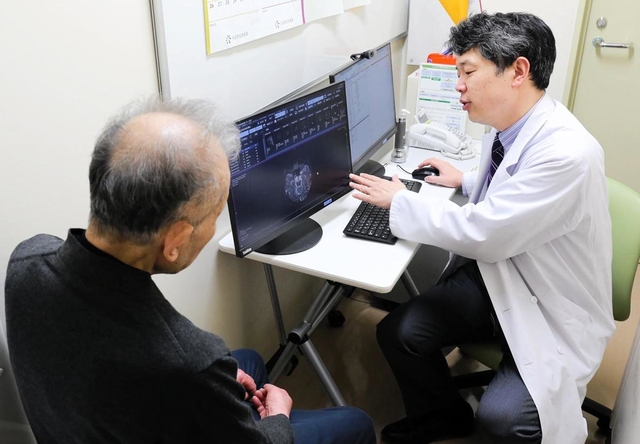 血管性認知症患者の男性（左）を診察する古和久朋教授＝神戸市中央区楠町７