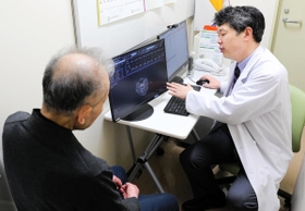 血管性認知症患者の男性（左）を診察する古和久朋教授＝神戸市中央区楠町７