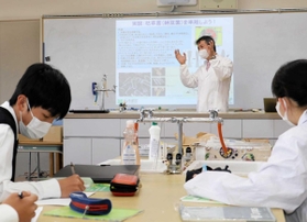 ため池の水質改善に向け、滝川第二高校の化学同好会を指導する三重大学の田丸浩教授（奥）＝神戸市西区春日台６