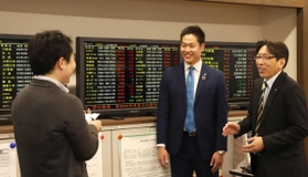  光証券の（右から）本田健志営業部長と大越智正大係長から投資の助言を受ける記者＝神戸市中央区加納町３