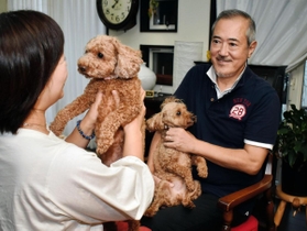 ２匹の愛犬と一緒に過ごす太田伸吾さん（右）さんと百合子さん＝豊岡市内