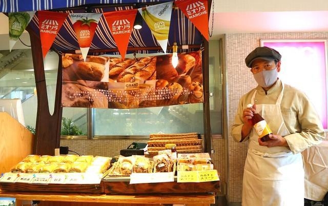 ミオソラマルシェ（天王寺）に出店中の滝野さん。手に持っているのはタイ産「ロンガン蜂蜜」