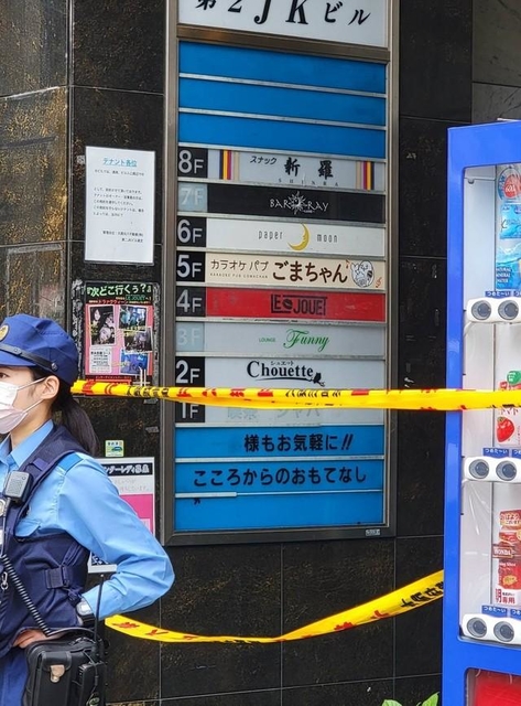 入口に規制線が張られた大阪市内の雑居ビル。案内板の５階部分には事件現場となった店名が記されていた(撮影・小川泰平)