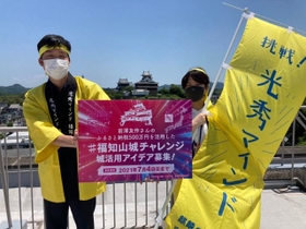 光秀ゆかりの福知山城をバックに意気込む市の職員