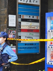 入口に規制線が張られた大阪市内の雑居ビル。案内板の５階部分には事件現場となった店名が記されていた(撮影・小川泰平)