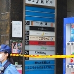 入口に規制線が張られた大阪市内の雑居ビル。案内板の５階部分には事件現場となった店名が記されていた(撮影・小川泰平)