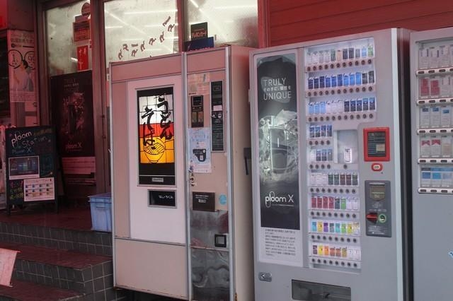 話題のレトロ自販機（左）と隣に並ぶ「PloomX」の自販機