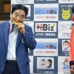 後藤希友投手（右）の金メダルを噛む河村たかし市長＝４日（提供・共同通信社）