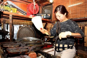 焼き型を器用に操る和田絵三子さん。一度焼き始めると、終わるまでほかのことはできないという