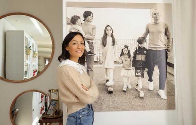 自宅に飾られた家族写真の前で笑みを浮かべるアンナ・オルティスさん＝神戸市内（撮影・小林良多）