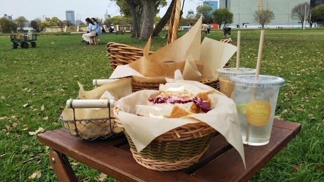 ピクニックを楽しむ人々の向こうにかすかに見える大阪城