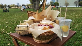 ピクニックを楽しむ人々の向こうにかすかに見える大阪城