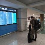 大きな荷物を背負って帰省先へ向かう兵役中の若者…ギターが心の友なのかも