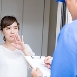 作業員の訪問に困った様子の主婦（buritora/stock.adobe.com)