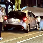 レンタカーの上に乗り、鉄道の写真を撮る男性ら（えさん＠CY3A_enerloov提供）※一部画像を処理しています