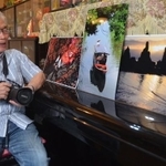 カメラを手に作品を眺める日下部さん。「写真を通じて感動を分かち合いたい」と語る（京都府南丹市園部町）