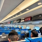東海道新幹線の棚の上がカオス…。右側の棚は訪日客のスーツケースでいっぱい。左側の棚からは、持ち込み予約が必要な特大荷物がはみ出している危険な状況（画像提供：yukapoさん @yukapova）