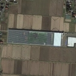 田んぼの中にあるプールのように見える建造物は野菜工場　（C）Google
