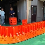 置いて繋ぐだけで設置できる止水板「Flood Guard F」（左端の人物が藤井社長）