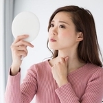 鏡を見て考えている女性※画像はイメージです（kei907/adobe.com/）